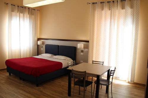 a bedroom with a bed and a table and chairs at Residence Circe in Taormina