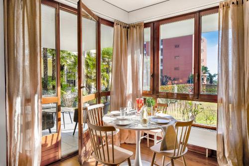 a dining room with a table and some windows at Casa Rinetta with Patio and A/C - Happy Rentals in Lugano