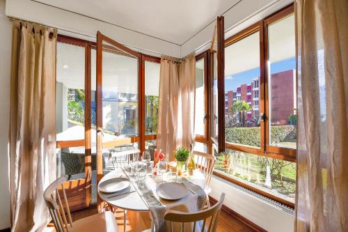 a dining room with a table and some windows at Casa Rinetta with Patio and A/C - Happy Rentals in Lugano