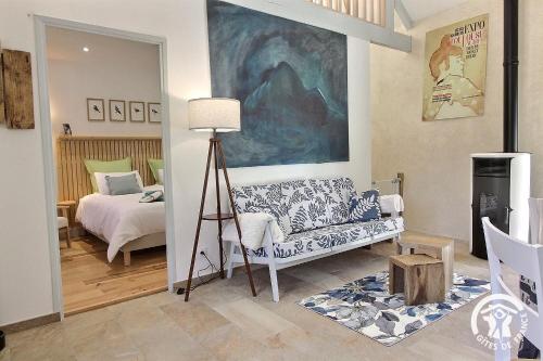 a living room with a couch and a bed at Le murmure des oiseaux in Plussulien