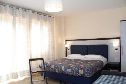 a bedroom with a bed and a chair and a window at Residence Circe in Taormina