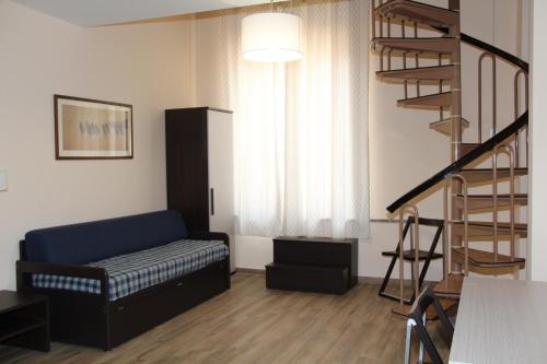 a living room with a couch and a spiral staircase at Residence Circe in Taormina