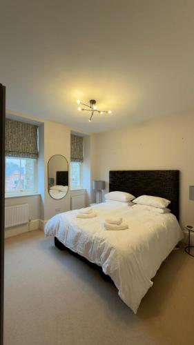 a large bedroom with a large bed with white sheets at Rutland Home in Langham