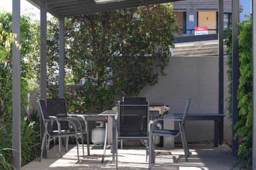 a group of chairs and a table in a patio at Gladstone Heights Executive Apartments in Gladstone