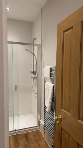 a bathroom with a shower with a glass door at Rutland Home in Langham