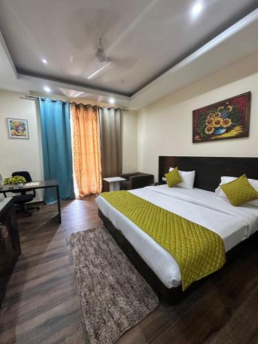 a bedroom with a large bed with a yellow blanket at VRResidency in Gurgaon