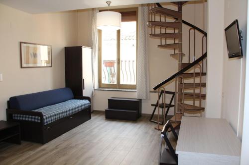 sala de estar con sofá y escalera de caracol en Residence Circe, en Taormina