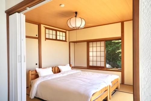 a bedroom with a bed and a window at 海を望む東伊豆の一棟貸し ula Ocean-view private stay in Izu in Higashiizu
