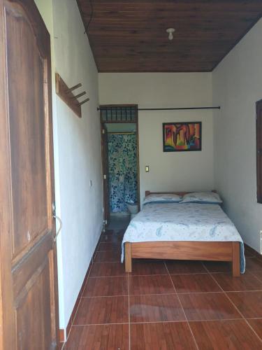 a bedroom with a bed and a wooden door at La Escondida in Jardin