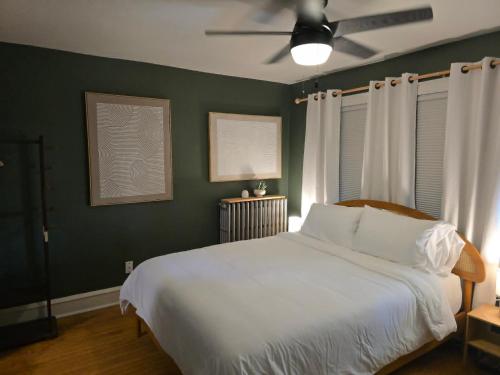 a bedroom with a white bed and a ceiling fan at Stylish Apt in Walker's Point in Milwaukee