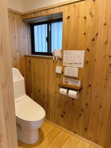 a bathroom with a toilet in a wooden wall at Guesthouse Nara IROHA in Nara