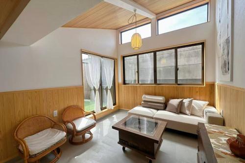 a living room with a couch and a table at Guesthouse Nara IROHA in Nara