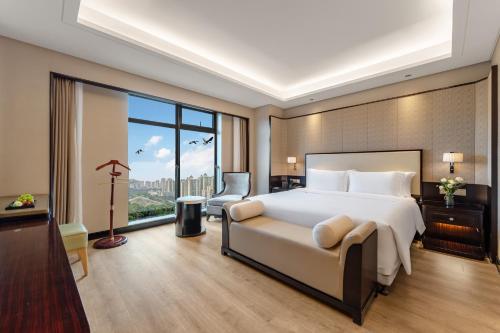 a bedroom with a large bed and a large window at Howard Johnson Jinyi Hotel Chongqing in Chongqing