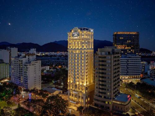 a lit up building in a city at night at Mercure Nha Trang Beach in Nha Trang