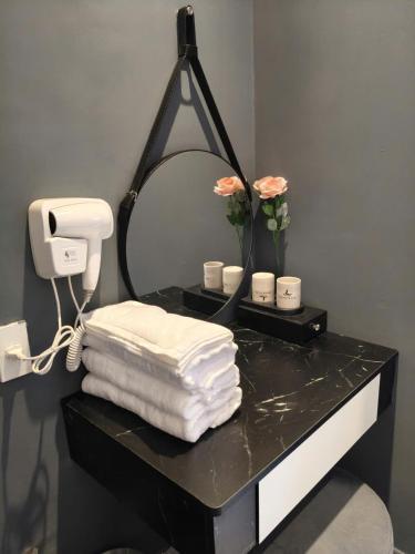 a bathroom with a mirror and towels on a black counter at Hoài Thu Luna Hotel in Ðông Hòa