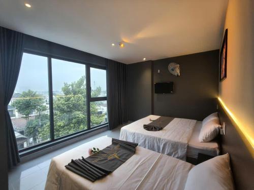 a hotel room with two beds and a large window at Hoài Thu Luna Hotel in Ðông Hòa