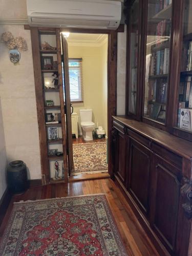 a hallway with a toilet in a room with a rug at Lear House Oamaru in Oamaru