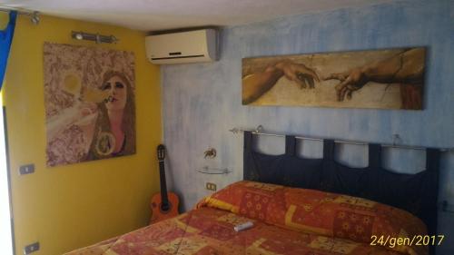 - une chambre avec un lit et deux peintures murales dans l'établissement Albergo Diffuso Culturart House, à Agrigente