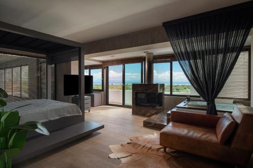a bedroom with a bed and a couch and a tv at Luxury Villa Christina in Makrygialos