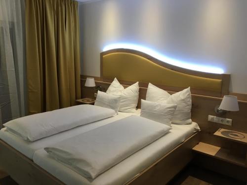 a bed in a hotel room with white pillows at Seminarhotel Daniels in Gols