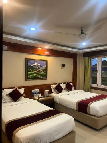 a hotel room with two beds and a window at Hotel Parkland in Sauraha