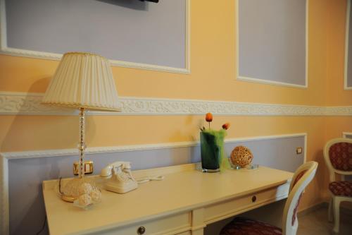 a table with a lamp and a vase on it at Hotel Villa Santa Maria in Villapiana