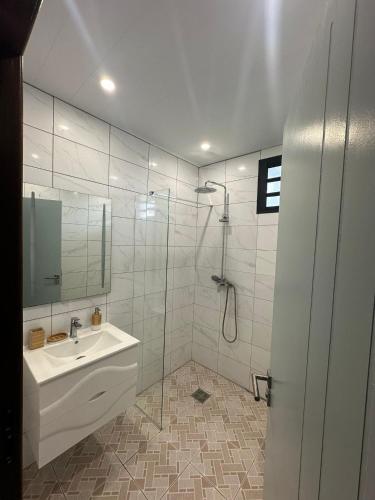 a bathroom with a sink and a shower at Heshima's Apartment for Business in Macouria