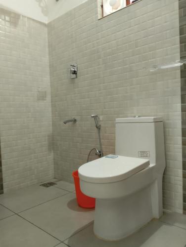 a bathroom with a white toilet in a room at Wayanad One in Wayanad
