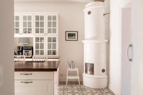 a kitchen with white cabinets and a white fireplace at C Apartments Annedal in Gothenburg