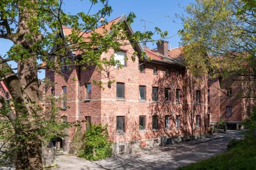 a large brick building with trees in front of it at C Apartments Annedal in Gothenburg