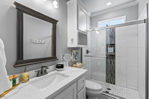 a white bathroom with a sink and a shower at The Elevated Spoonbill Dog-Friendly Beach Retreat in Bolivar Peninsula
