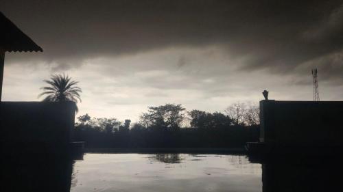 a view of a pond with a cloudy sky at Kevda Crown Estate in Keora