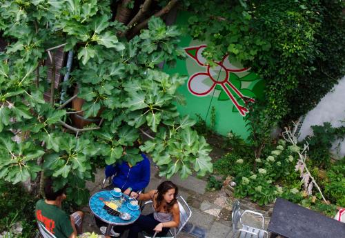 a woman sitting at a table in a garden at Strowis Hostel in Utrecht
