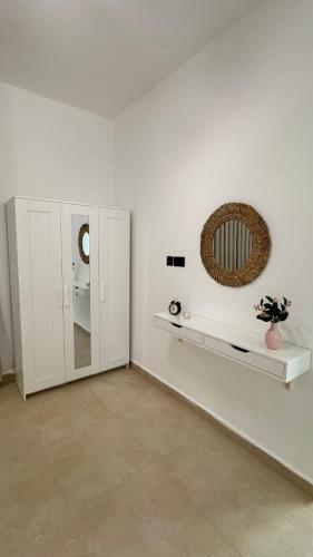 a white room with a mirror and a toilet at The Inn Salalah in Salalah