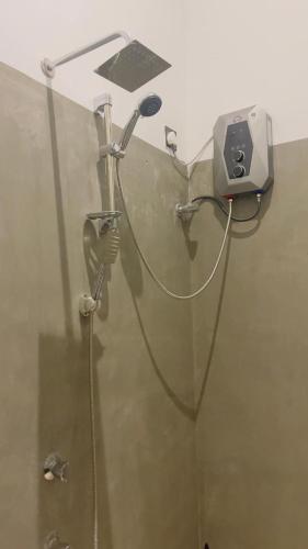 a shower with a blow dryer on a wall at Ck resort in Weligama