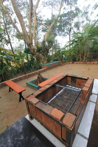 a wooden bench sitting next to a park with trees at Wayanad One in Wayanad
