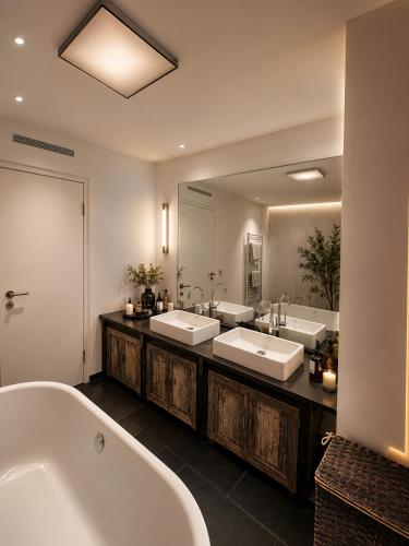 a bathroom with two sinks and a tub and a large mirror at Marienplatz Design Apartment - Historic Center in Munich