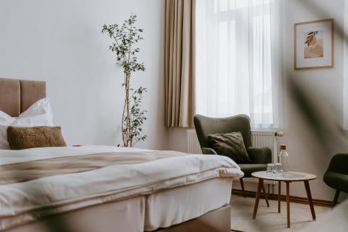 a bedroom with a bed and two chairs and a window at Penzion Pod Kašnou in Frýdek-Místek