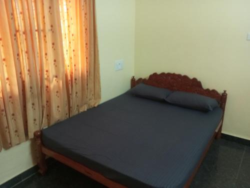 a bedroom with a bed in a room with a curtain at Dream Stay in Varkala