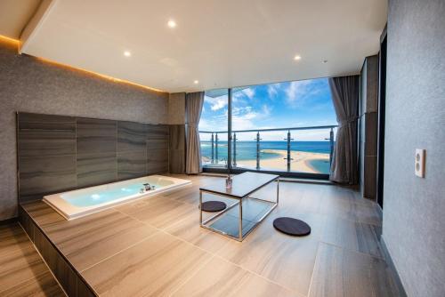 a bathroom with a tub with a view of the ocean at Soakcho Pool View Spa Pool Villa in Sokcho