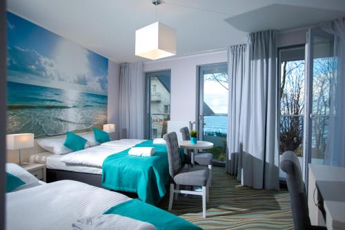 pokój hotelowy z 2 łóżkami i stołem w obiekcie Gwiazda Morza w Rewalu
