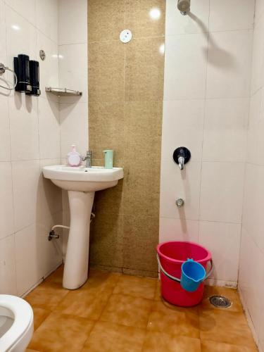 a bathroom with a sink and a shower and a bucket at The Sandstone Studio in Dehradun