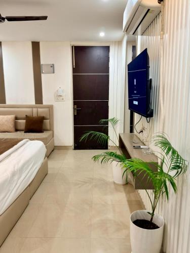 a living room with a bed and a tv in it at The Sandstone Studio in Dehradun