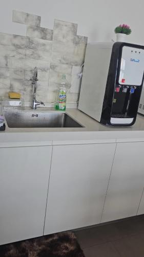 a kitchen counter with a sink and a cell phone at Swiss belhotel apartment in Kuantan