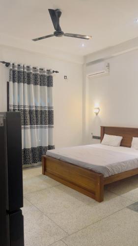 a bedroom with a bed and a ceiling fan at Ck resort in Weligama