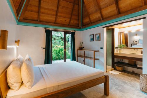a bedroom with a bed and a large window at Bravo Beach Resort in General Luna