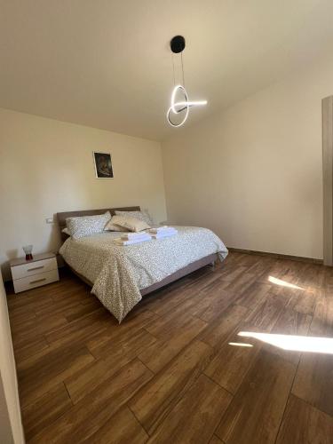 a bedroom with a bed and a wooden floor at La terrazza di Isma in Ghizzano
