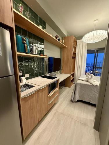 a kitchen with wooden cabinets and a bed in a room at Setin Downtown | Conforto no Centro de SP in São Paulo