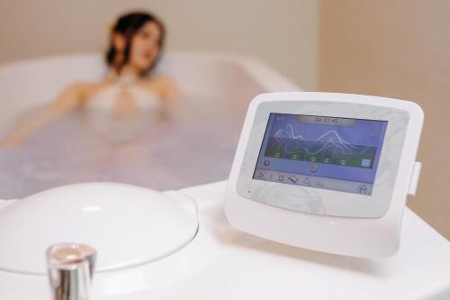 a woman in a bath tub with a scale at HOTEL CRYSTAL WELLNESS & SPA superior in Sovata
