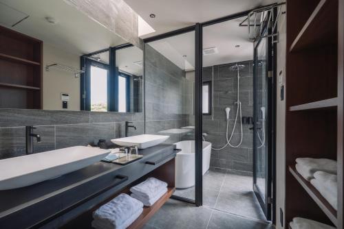 a bathroom with a tub and a sink and a shower at Villa Azure Mira in Miyakojima